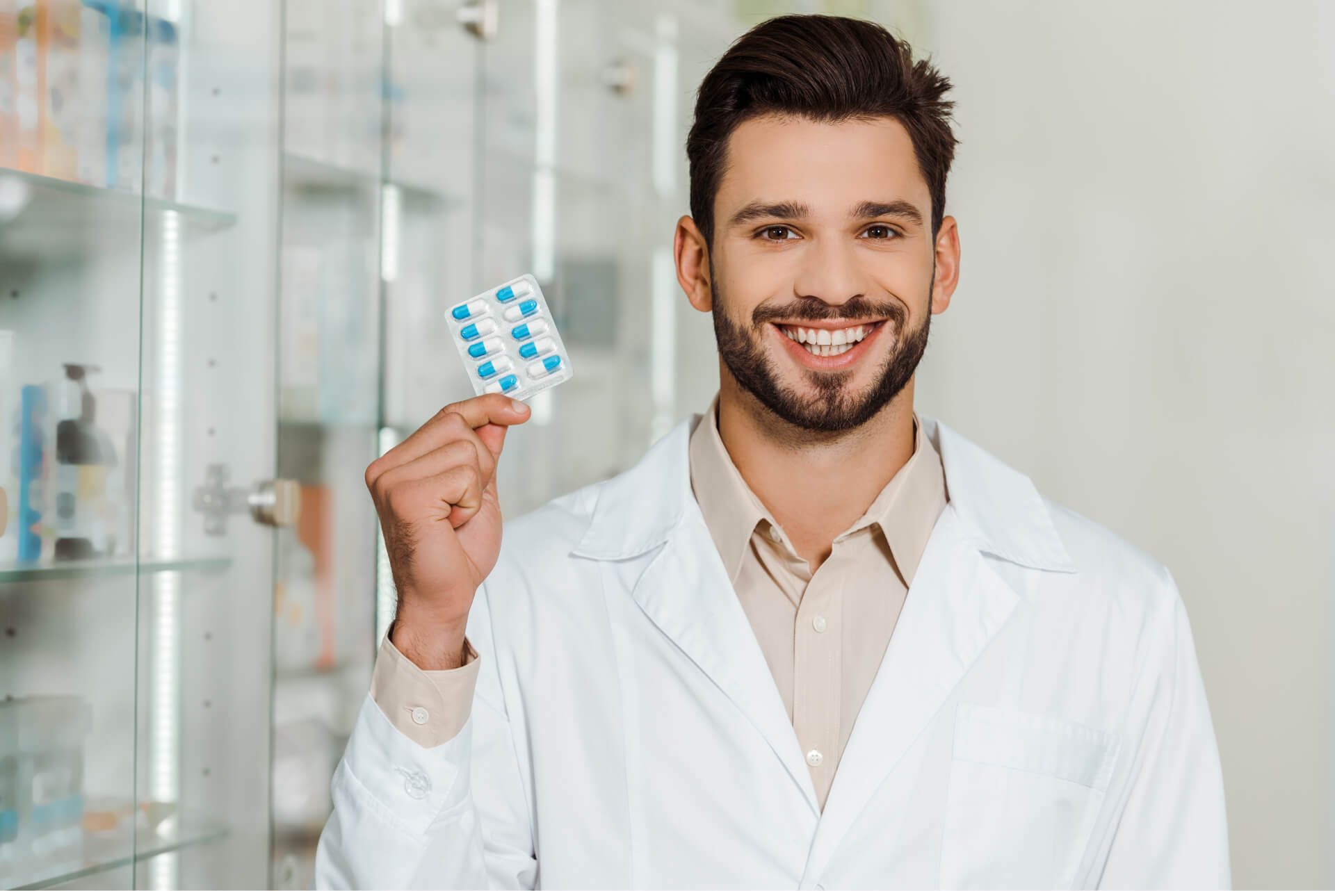 handsome-pharmacist-smiling-at-camera-while-holdin-2023-11-27-05-12-27-utc.jpg